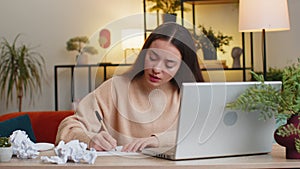 Angry furious woman working at home office throwing crumpled paper having nervous breakdown at work