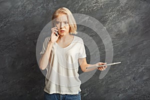 Angry girl arguing by mobile at black studio background