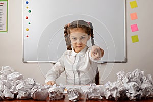 Angry girl in classroom pointing to the camera