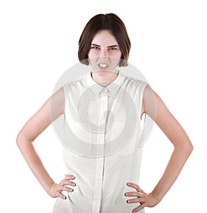 An angry girl. Disgusted girl with hands on hips. A female isolated on a white background. A brunette young woman in a blouse.