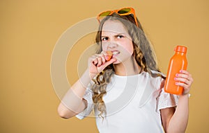 Angry girl drink fresh carrot juice. summer vacation. little girl in fashion glasses. Vitamin nutrition. refreshing