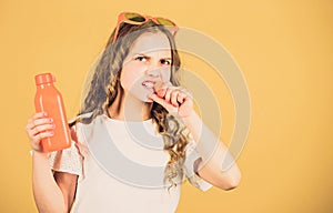 Angry girl drink fresh carrot juice. summer vacation. little girl in fashion glasses. Vitamin nutrition. refreshing