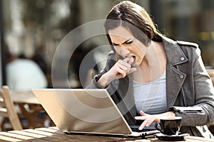 Angry girl frustrated using her laptop on a terrace