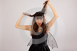 Angry girl pulling hair black dress wings