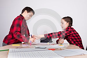 Angry girl removing pencil from child at school