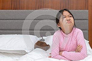 Angry girl sitting on bed and touchy, upset and annoyed emotion