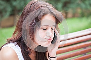 Angry girl talking on mobile phone with closed eyes.