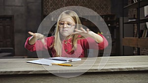 Angry girl throwing books out of the table at home