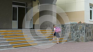 Angry girls go to school upstairs with backpack. Back to school concept. Funny shot of young caucasian girl backpack