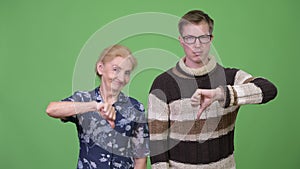 Angry grandmother and grandson giving thumbs down together