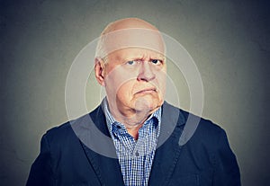 Angry, grumpy senior business man, isolated on gray background