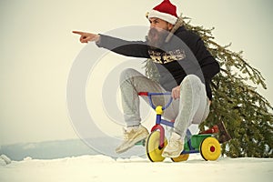 Angry hipster carrying xmas tree on white snow