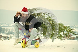 Angry hipster carrying xmas tree on white snow