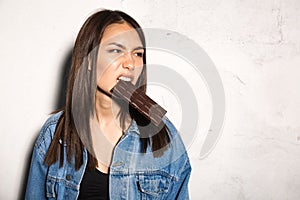Angry hipster woman eating chocolate