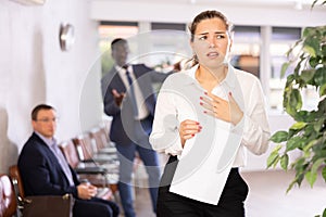 Angry hot-tempered boss shouts yells at hired employee girl in office reception.