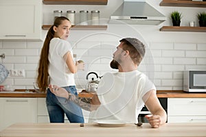 Angry husband and shocked wife arguing having conflict in kitche photo
