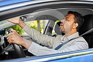 angry indian man or driver driving car