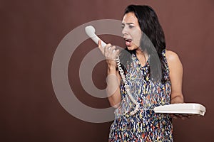 Angry indian woman talking on landline phone, shouting