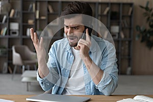 Angry irritated man talking on phone, arguing or complaining