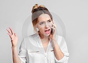 Angry irritated woman talking on mobile phone