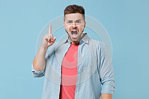 Angry irritated young bearded guy 20s in casual shirt posing isolated on pastel blue background in studio. People