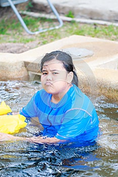 Angry Little Asian Girl swimming in swimming pool
