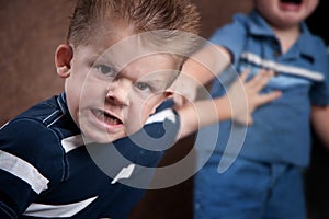 Angry little boy glaring and fighting photo