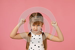 Angry little child girl in dress raising fist