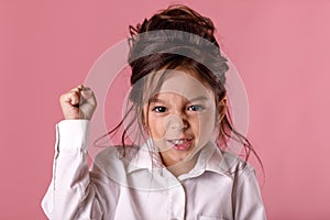 Angry little child girl in white shirt with hairstyle