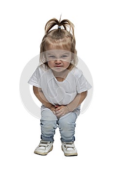 Angry little girl 2-3 years old in jeans is squatting. Isolated on white background. Vertical