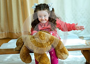 Angry little girl beating her teddy bear - domestic abuse concept. Girl 4-5 year old punishes toy bear