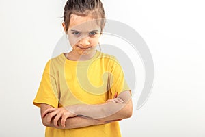 Angry little girl with folded hands on a white background isolated.