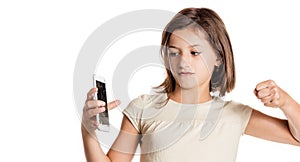 Angry little girl holding a smartphone with broken screen