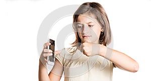 Angry little girl holding a smartphone with broken screen