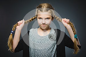 Angry little girl isolated on gray background.