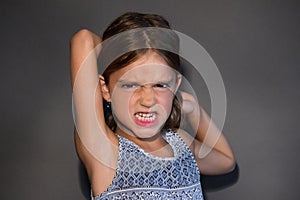 Angry little girl isolated on silver background