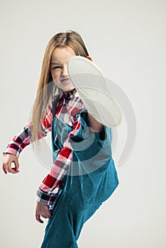 Angry little girl kicks. children`s fashion studio shooting. kid emotion