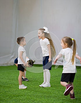 An angry little girl with long hair is shouting on a boy on the football field