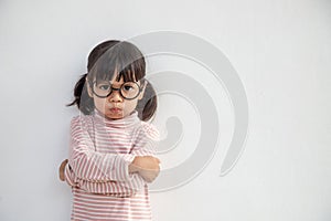 Angry little girl over white background, sign and gesture concept