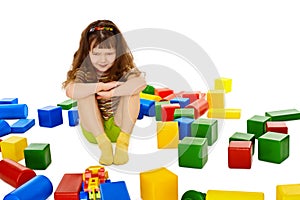 Angry little girl among the scattered toys