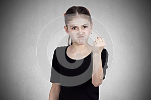 Angry little girl showing fist to someone