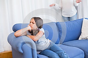 Angry little girl sitting on the couch