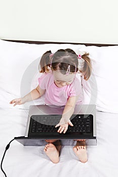 Angry little girl sitting in front of a laptop