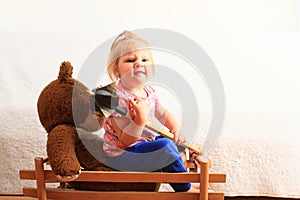 Angry little girl with Teddy bear on carriage