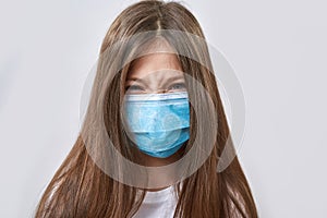 Angry little girl wear medical mask look at camera