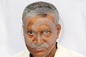 Angry looking senior Indian man face portrait on white background.