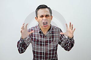 Angry mad asian indonesian man with pointing finger gesture on isolated background
