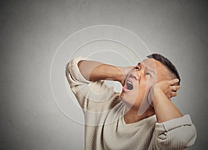 Angry mad unhappy stressed man covering his ears looking up