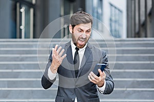 Angry male businessman cry talking on the phone outside business man shouting on call outdoors. Nervous mad professional