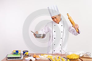 angry male chef holding bowl of dough and rolling pin